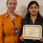 Two women standing next to each other holding a certificate.