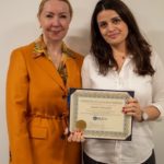 Two women holding a certificate and smiling.