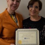 Two women holding a certificate of recognition